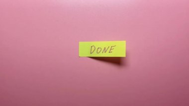 Bir el, üzerinde pembe bir arkaplan olan bir çıkartmayı soyar..