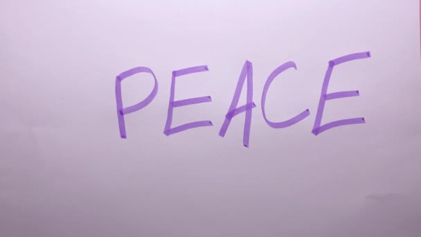 Sebuah Tangan Meremukkan Selembar Kertas Putih Dengan Tulisan Perdamaian — Stok Video
