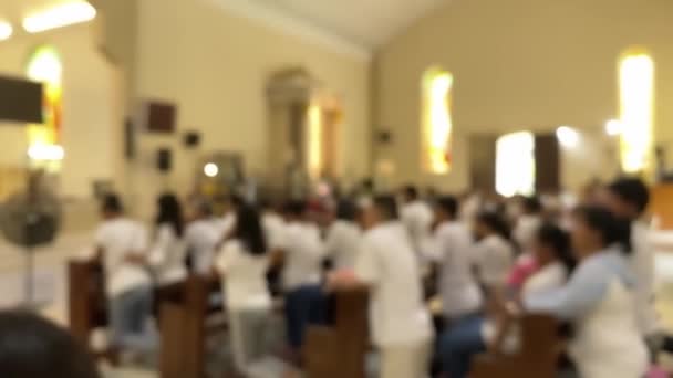 カトリックの教会で祈る人々 焦点からぼやけたイメージ — ストック動画