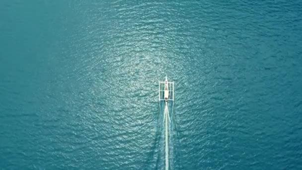 小さなボートがクリスタルブルーの水の上を帆走する アリアルビュー — ストック動画
