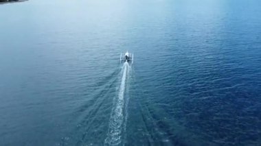 Küçük tekne kristal mavi su üzerinde yelken açar. Arial görünüm.