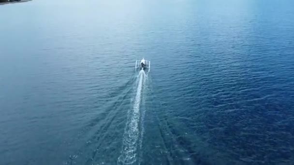 小さなボートがクリスタルブルーの水の上を航行します アリアルビュー — ストック動画
