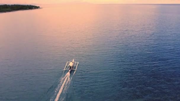 小さな漁船が夜明けに向かって海を航行する エアリアルビュー — ストック動画