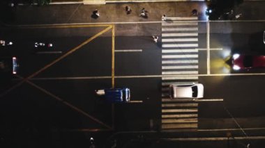 Gece şehir yollarının tepesinde hava manzaralı arabalar var. Sinematik araç manzarası. Yaya geçidi.