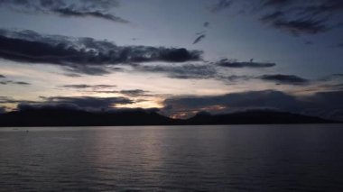 Tropikal dağların ve bulutların arka planına karşı denizin üzerinde şafak vakti.