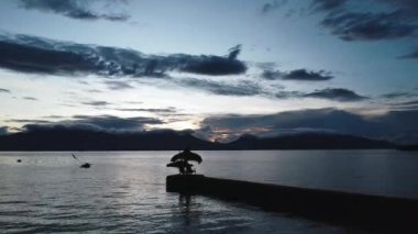 Tropikal dağların ve bulutların arka planına karşı denizin üzerinde şafak vakti.
