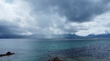 Şiddetli yağış arka planda dağlarla birlikte denizin üzerinde