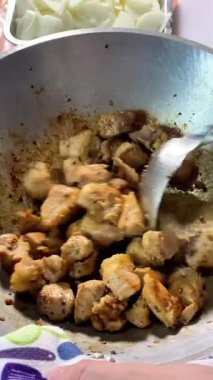 Et büyük bir tavada kızartılıyor, eti metal bir spatulayla karıştırıyor..