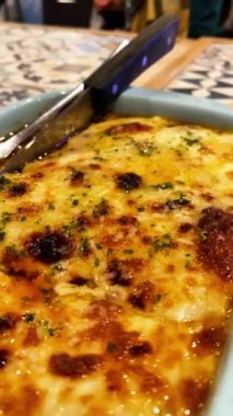 Seramik bir tencerede bir restoranda servis edilen yeni hazırlanmış lazanya.. 