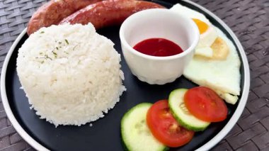 Pilavlı kahvaltı, kızarmış yumurta ve kızarmış sosis.