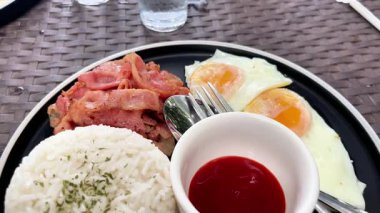Bir kafede kızarmış yumurta, pirinç ve domuz pastırması ile klasik kahvaltı.