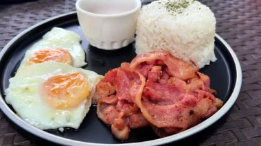 Bir kafede kızarmış yumurta, pirinç ve domuz pastırması ile klasik kahvaltı.