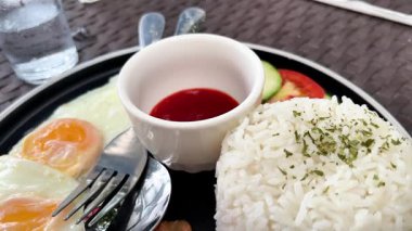 Bir kafede kızarmış yumurta, pirinç ve domuz pastırması ile klasik kahvaltı.