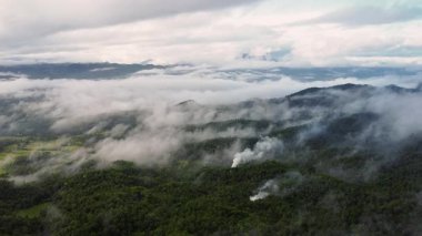 Tropikal dağ manzarası ve şafak vakti bulutlar ve sisle kaplı vadi. 