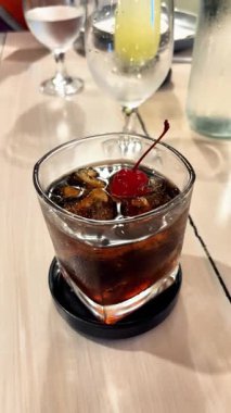 Viski ve kola kokteyli, maraska vişneli ve buzlu.. 