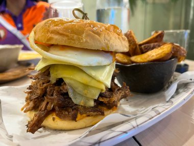 Büyük bir hamburger, fırında patates ve masada bir bardak viski..