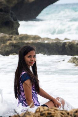 Okyanus dalgası gibi gülümseyen bir kadın arkasında çarpar..