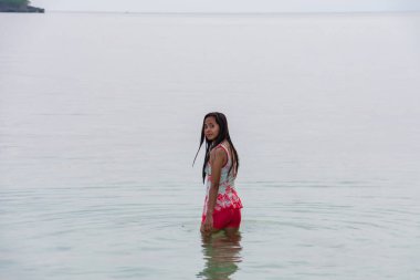 Mayolu genç bir kadın sabahın erken saatlerinde beline kadar berrak tropik deniz suyuna batmış..