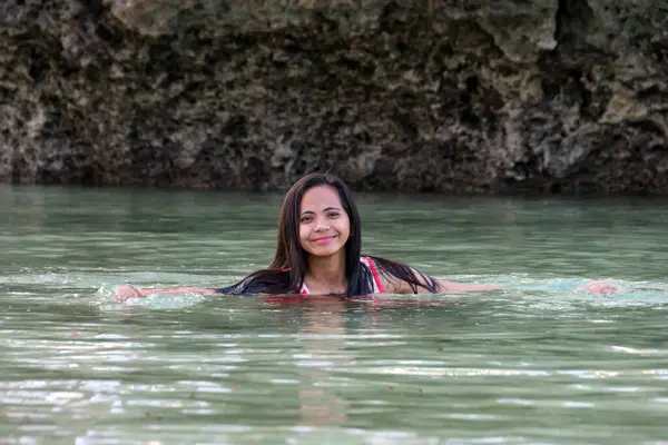  Kadın arkada kayalarla tropikal nehirde yüzüyor..