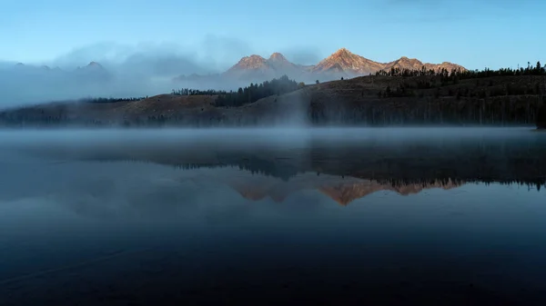 立ち上がる霧と沢歯の山の湖の朝 — ストック写真