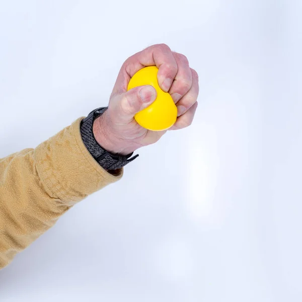 stock image Yellow stress ball being used close up