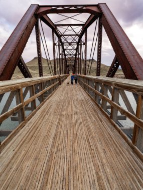 İnsanlar Snake River Idaho üzerindeki eski köprüde köpekleriyle yürümekten hoşlanırlar.