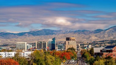 Autumn colored trees before the Boise skyline clipart