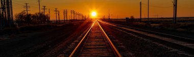 Turuncu gökyüzü ile demiryolu rayları üzerinde gün doğumu