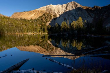 Idaho dağlarının tepelerinde gün batımı ve göl yansıması