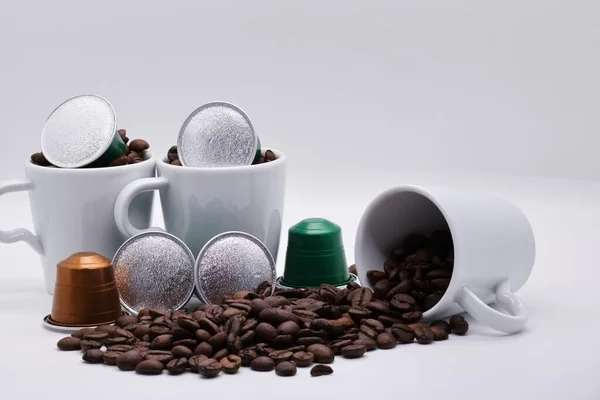 Close-up of coffee capsules and cups