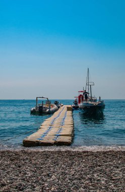 Boats and jet skis moored at a pier in the Adriatic Sea, Montenegro. clipart