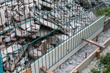  Beton temeller için çit. Beton dökmek için inşaat. Beton temeli olan bir çit inşa etmek.