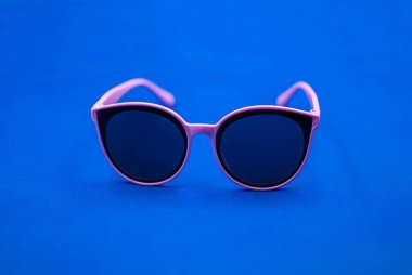 Mavi arkaplanda pembe güneş gözlüğü