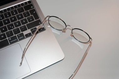Gri arkaplanda dizüstü bilgisayar ve gözlük