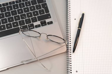 Gri arkaplanda dizüstü bilgisayar ve gözlük