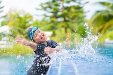 Mutlu çocuklar, yüzme havuzunda güneş gözlüklü şirin bir kız.