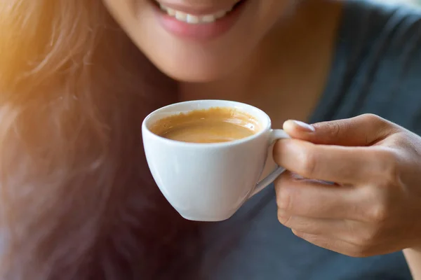 在咖啡店喝浓缩咖啡的女人 免版税图库图片