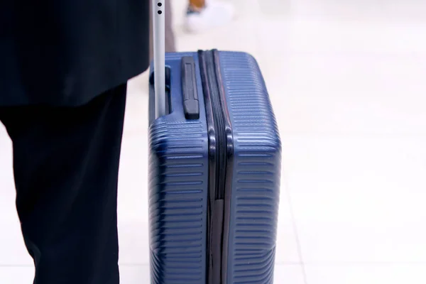 Businessman drag luggage or suitcase walking in airport terminal for air transport and traveling theme.
