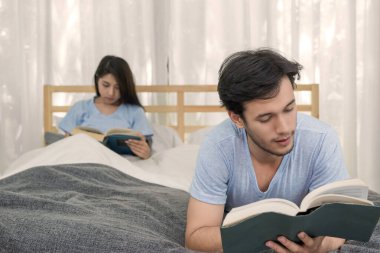 Genç seven çift yatak odalı evde üzerine bir kitap okuma.