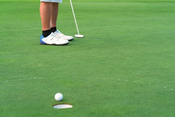 高尔夫球场绿地上的高尔夫球手把高尔夫球打进洞中 — 图库照片