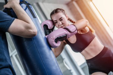 Boks eldiven yakışıklı adam güzel sporcu fitness salonunda çanta egzersiz delme