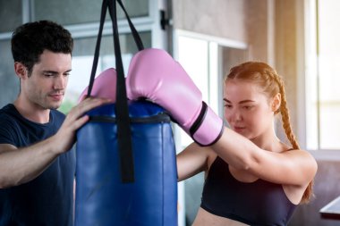 Boks eldiven yakışıklı adam güzel sporcu fitness salonunda çanta egzersiz delme.