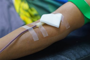 Elinde şişme bir topla kan bağışı yapan bir adam..