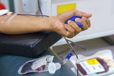 Elinde şişme bir topla kan bağışı yapan bir adam..