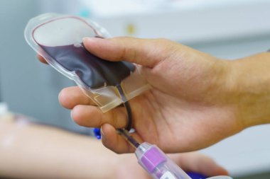 Elinde şişme bir topla kan bağışı yapan bir adam..