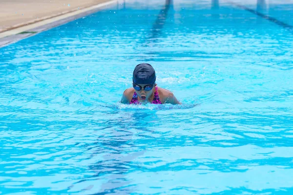 child swimmer swim in swimming pool. Water sports training and competition, learning to swim classes for children.