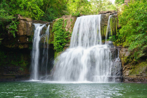Klong Chao waterfall serenely cascades and green water below in Koh Kood island, Thailand