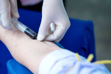 Nurse collecting a blood from patient in hospital. clipart