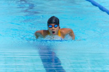 Yüzücü çocuk yüzme havuzunda kelebek yüzme stili yüzer. Su sporları ve yarışma, çocuklar için yüzme dersleri..