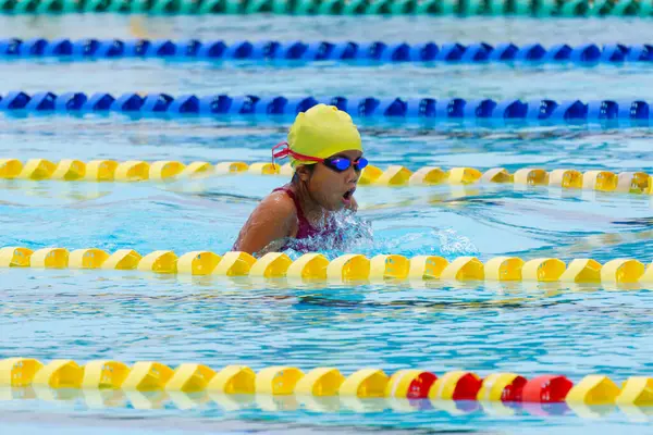 Yüzücü çocuk yüzme havuzunda kurbağalama yüzme stili yüzer. Su sporları ve yarışma, çocuklar için yüzme dersleri.